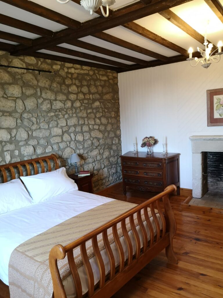 Countryside gîte bedroom with traditional stone wall in Charente SW France
